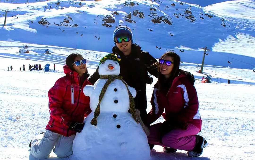 Família na neve da base do vulcão Villarrica, em Pucón
